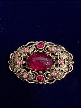 This vintage 1960s German brooch gold-tone filigree frame.